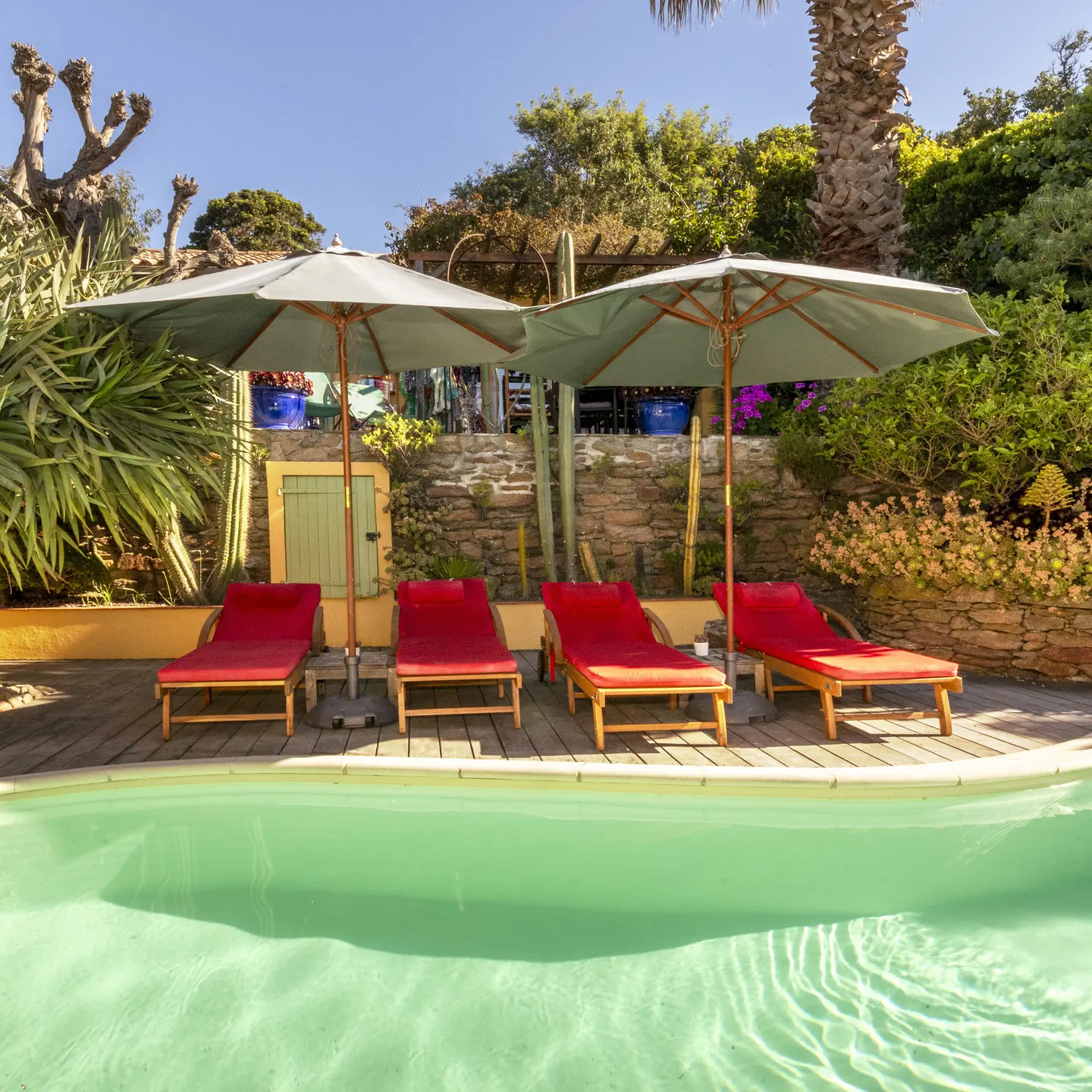 Piscine bordée de transats rouges