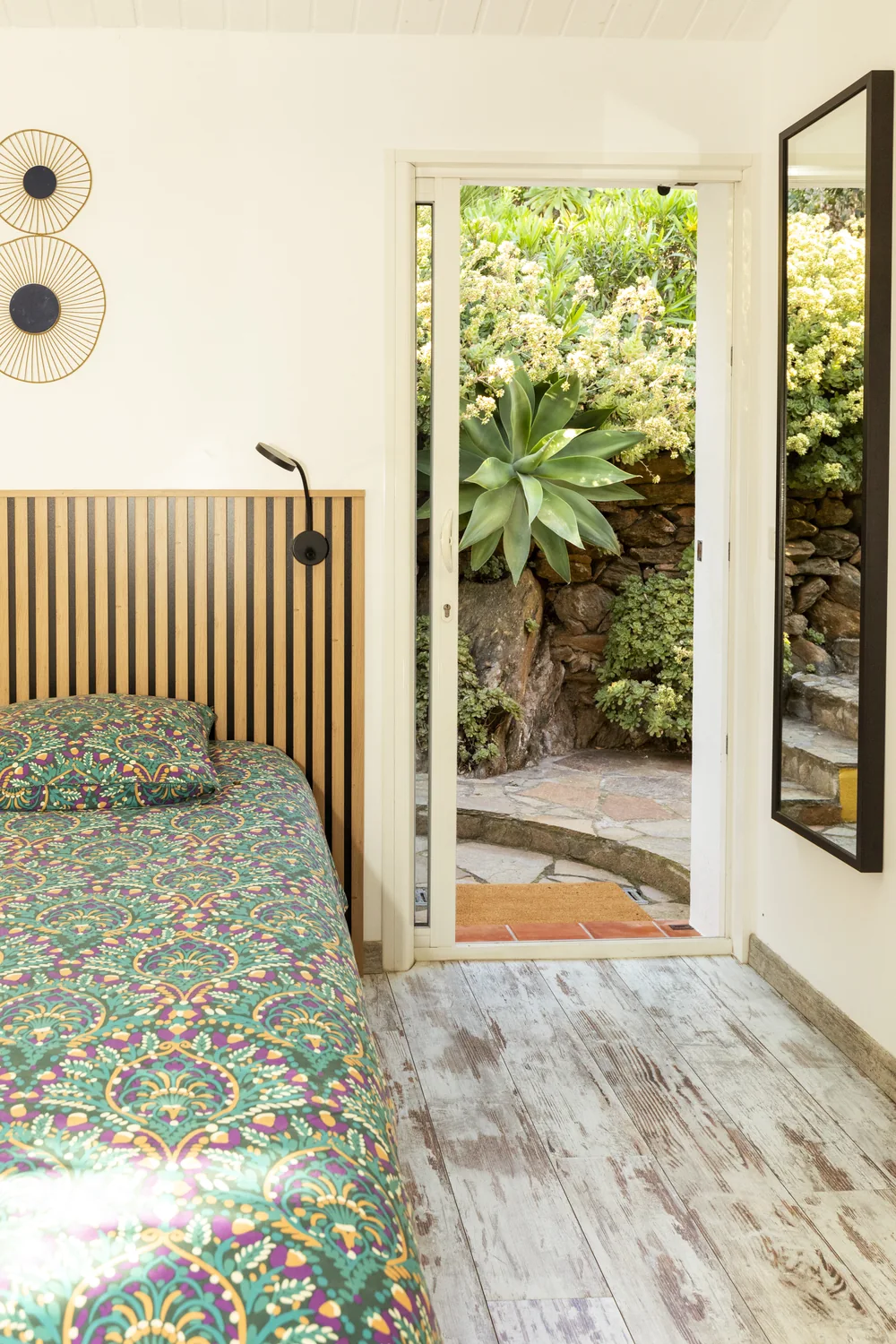 Lit du studio Brava et porte ouverte sur le jardin de la Villa Cabo Verde